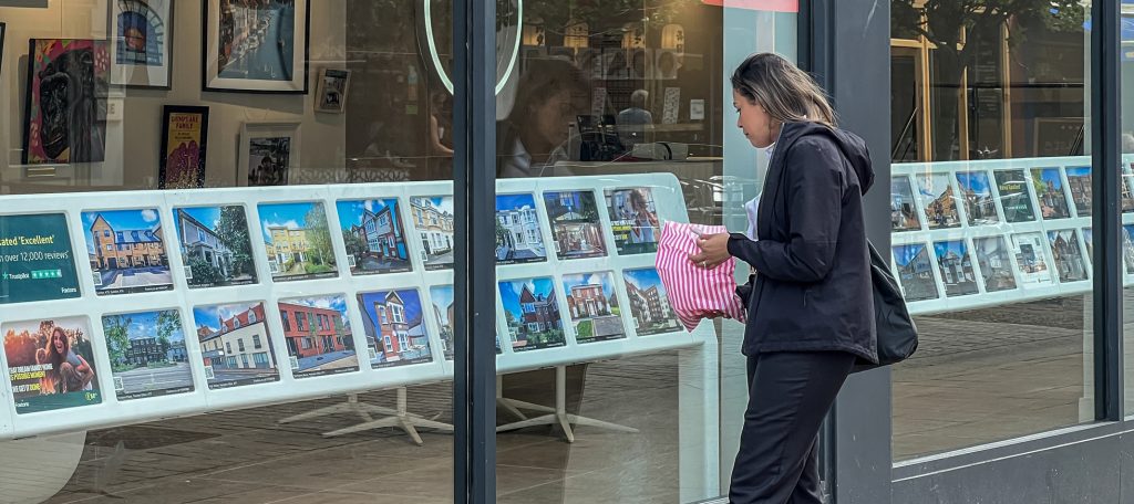 femme consultant les annonces immobilière en vitrine