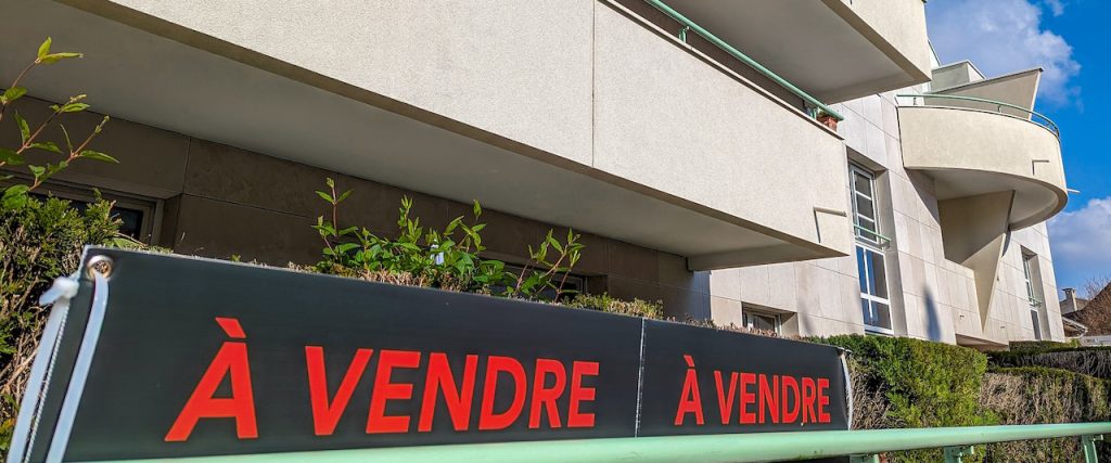 panneau de vente au pied d'un immeuble